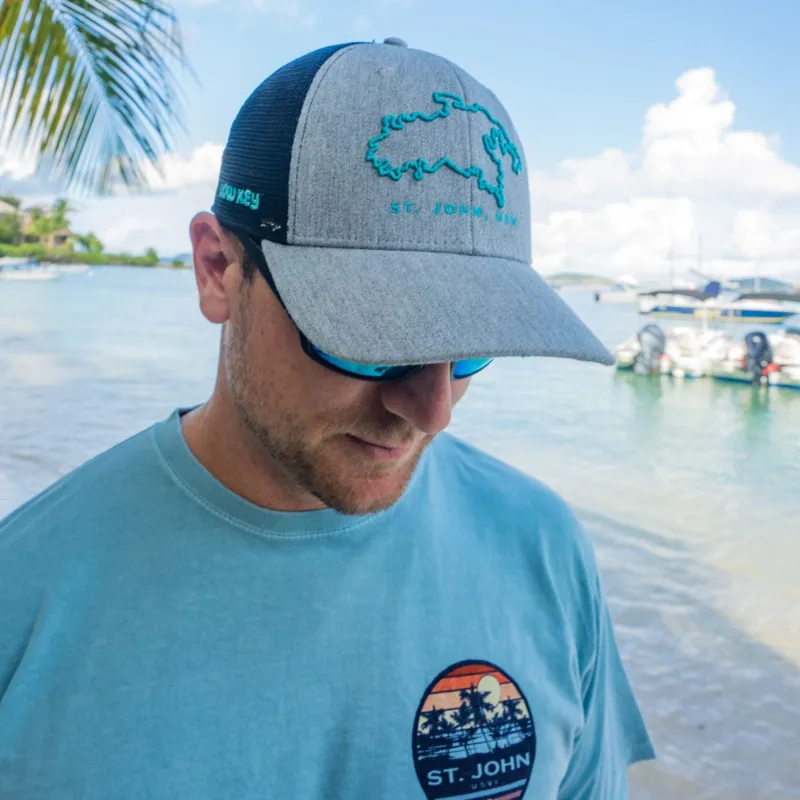 pukka gry a man wearing a hat and glasses with water in the background